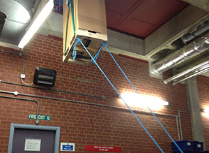 UPS (uninterruptible power supply) being hoisted up and through a small opening during installation by Enhanced Power Services Ltd.